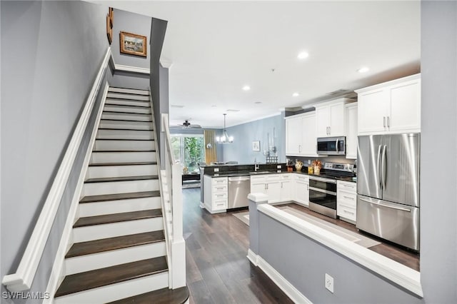 16118 Ravina Way, Naples, FL 34110 - kitchen with a sink, a peninsula, dark wood-style floors, stainless steel appliances, and white cabinetry