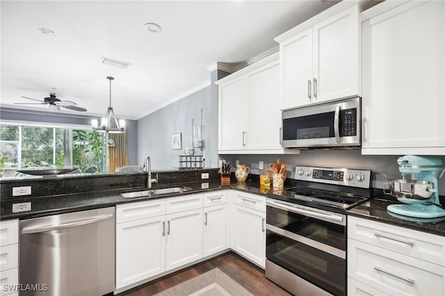 kitchen with stainless steel appliances, sink, white cabinets, and dark stone counters