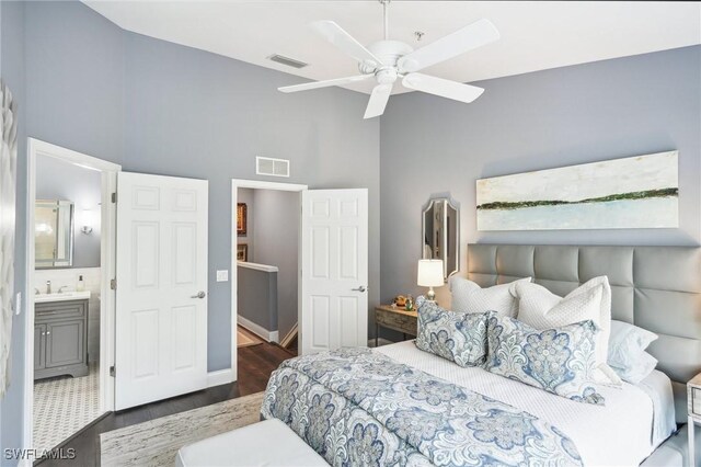 bedroom with ceiling fan, dark wood-type flooring, ensuite bathroom, and sink