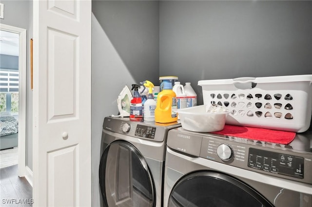 clothes washing area featuring wood-type flooring and washer and dryer