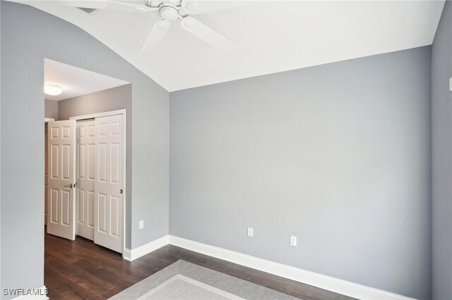 spare room featuring ceiling fan, dark hardwood / wood-style flooring, and lofted ceiling