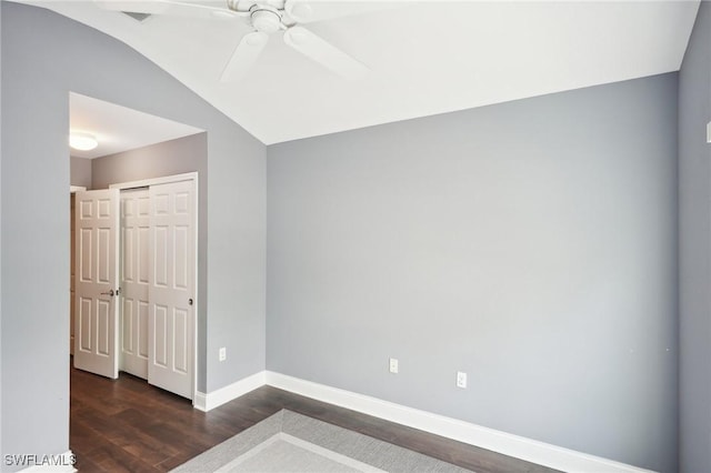 empty room featuring ceiling fan, lofted ceiling, and dark hardwood / wood-style floors