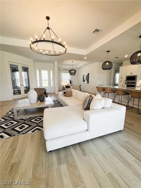 living room featuring a tray ceiling and a chandelier