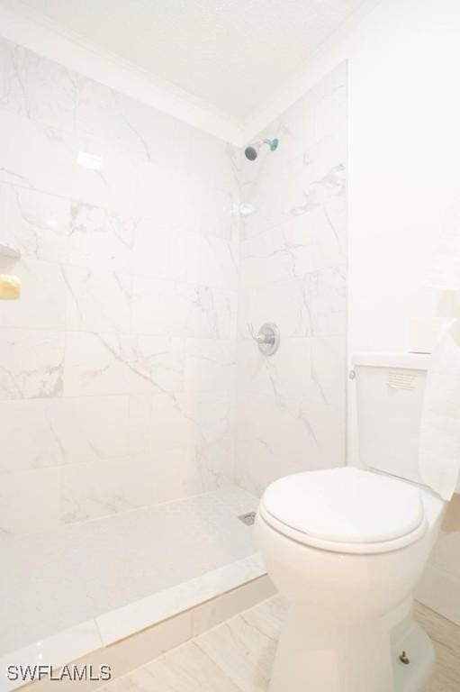 bathroom featuring tiled shower and toilet