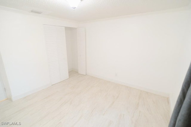 spare room featuring a textured ceiling and ornamental molding