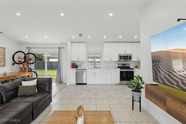 living room featuring sink and light tile patterned floors