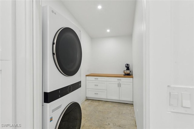 clothes washing area with stacked washer / dryer