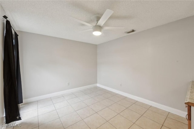 spare room with light tile patterned floors, a textured ceiling, and ceiling fan