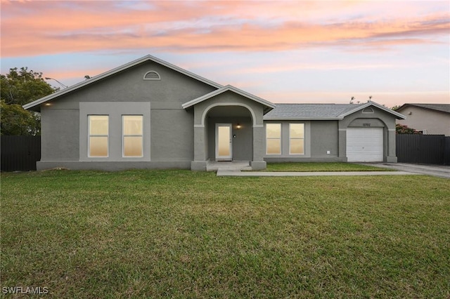 ranch-style home with a yard and a garage