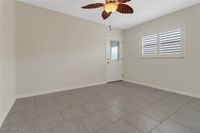 spare room with ceiling fan and light tile patterned flooring