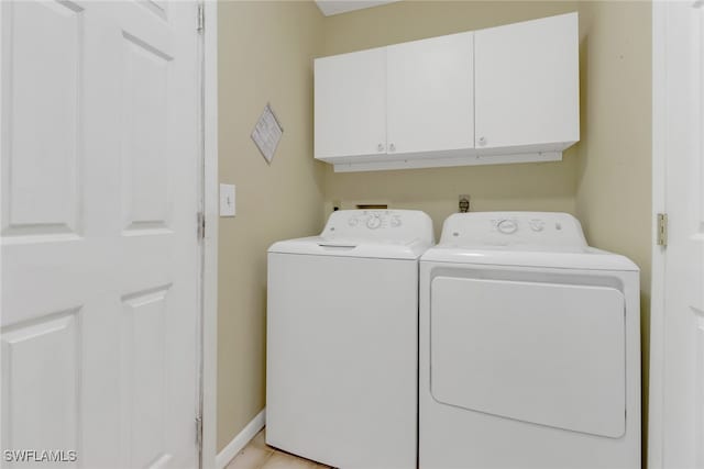 washroom with washer and clothes dryer and cabinets