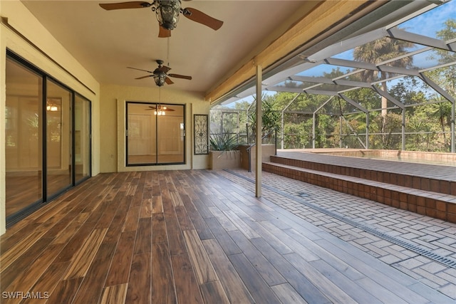 unfurnished sunroom with ceiling fan