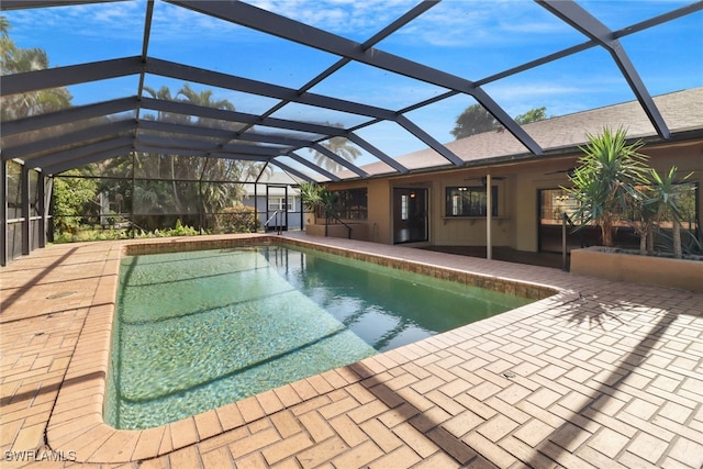 view of pool with ceiling fan, a patio area, and a lanai