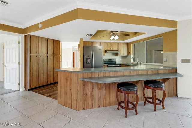 kitchen with decorative backsplash, kitchen peninsula, and appliances with stainless steel finishes