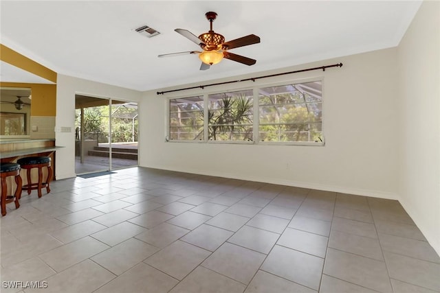 spare room with ceiling fan and light tile patterned floors