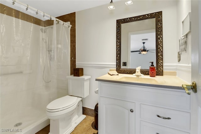 bathroom with curtained shower, ceiling fan, tile patterned flooring, toilet, and vanity