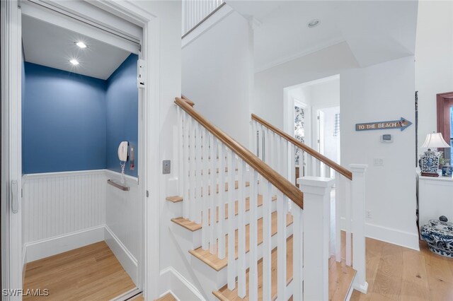 stairs with hardwood / wood-style floors and elevator