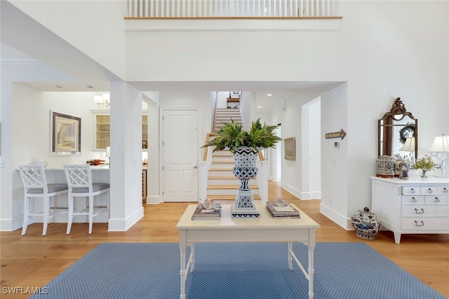 entrance foyer featuring a towering ceiling and light hardwood / wood-style floors