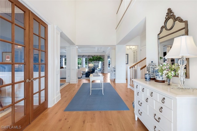 interior space with french doors, ornate columns, and light hardwood / wood-style floors