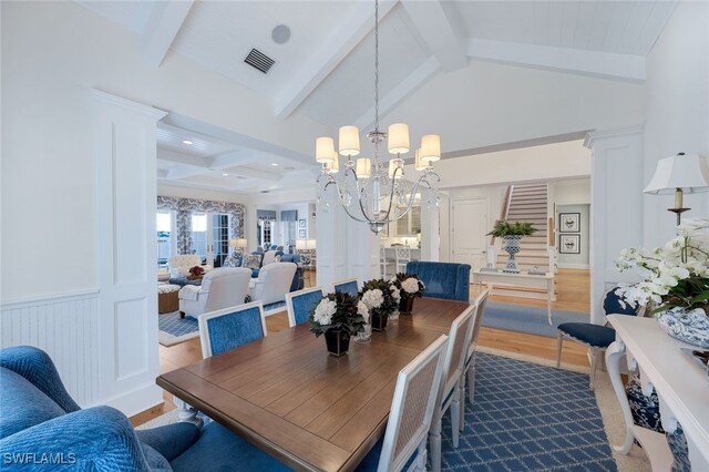 dining area featuring a chandelier, hardwood / wood-style flooring, and lofted ceiling with beams