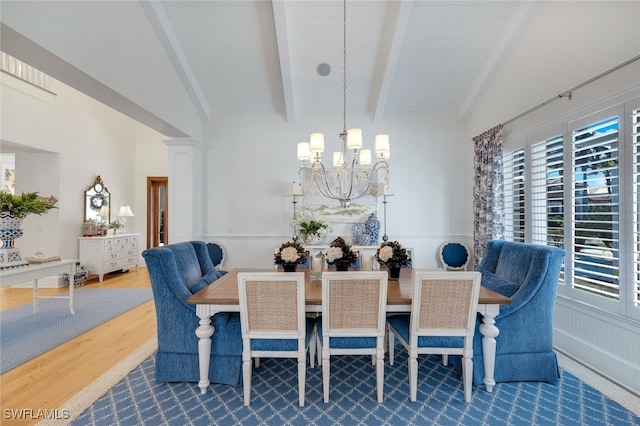 dining space featuring a notable chandelier, wood-type flooring, and lofted ceiling with beams