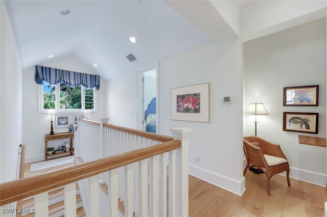 hall featuring lofted ceiling and light hardwood / wood-style floors