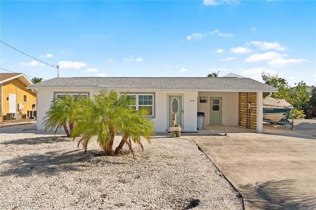 single story home featuring a carport and cooling unit