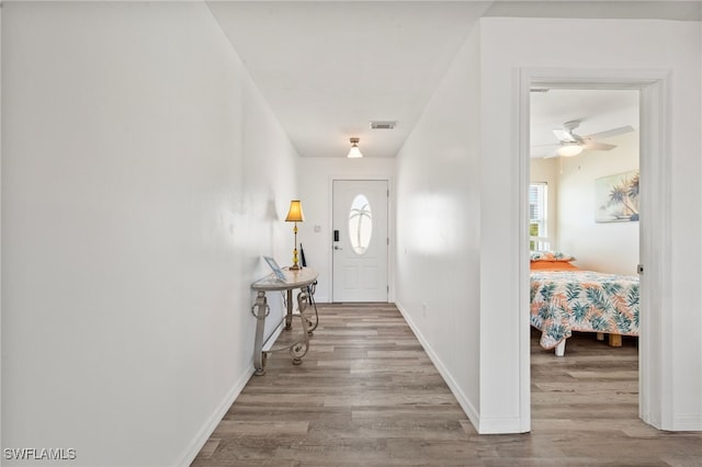 foyer entrance with ceiling fan and light hardwood / wood-style flooring