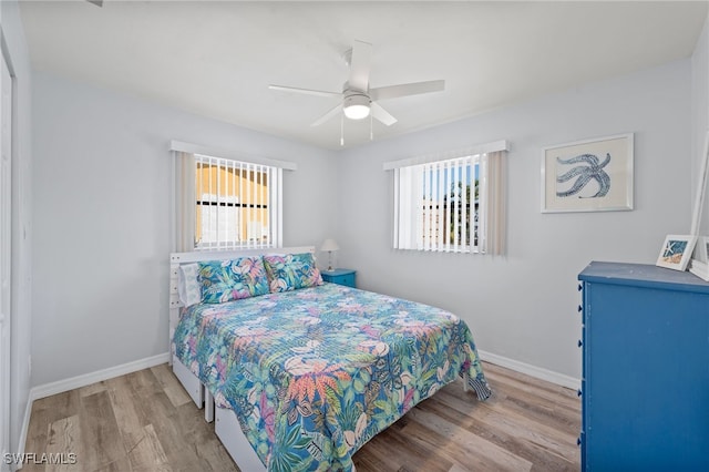 bedroom featuring multiple windows, ceiling fan, and wood-type flooring