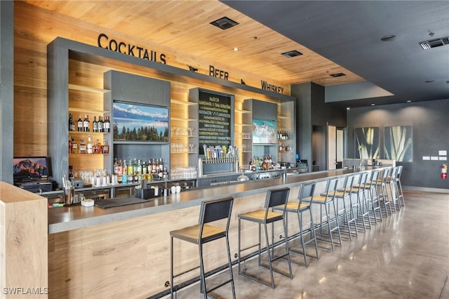 bar with concrete flooring and wooden ceiling