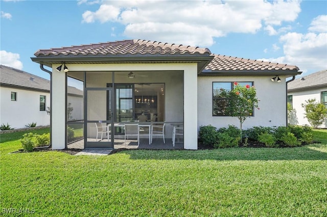 rear view of property featuring a sunroom and a lawn