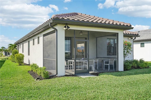 rear view of property with a sunroom and a lawn