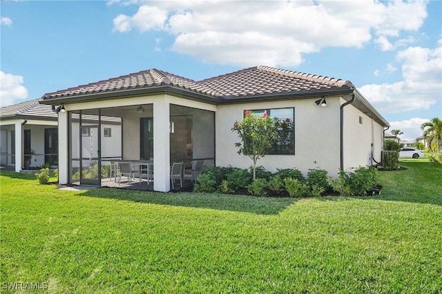 back of house with a yard and a sunroom