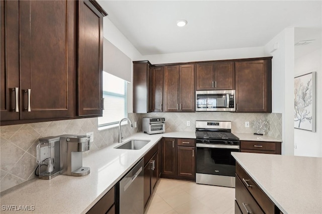 kitchen with appliances with stainless steel finishes, sink, dark brown cabinets, and decorative backsplash