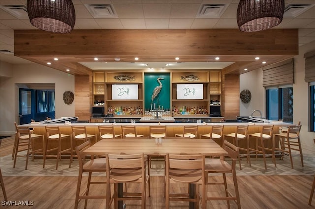 bar with beam ceiling and light hardwood / wood-style flooring