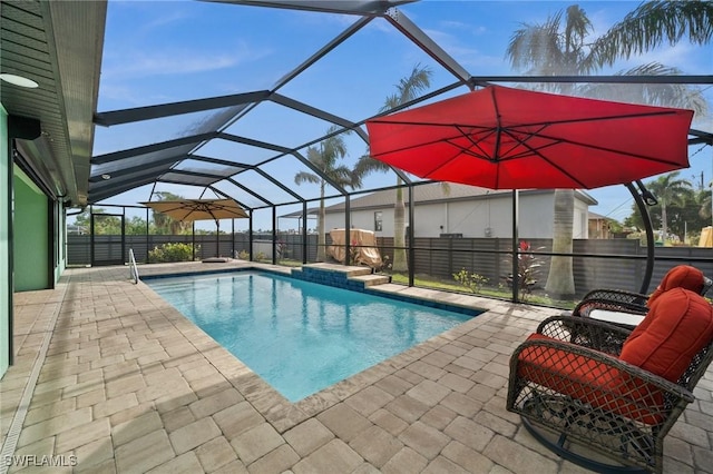 view of pool featuring glass enclosure and a patio