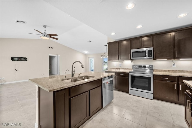 kitchen featuring pendant lighting, a kitchen island with sink, sink, vaulted ceiling, and appliances with stainless steel finishes