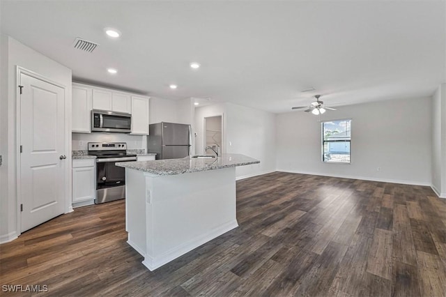 kitchen featuring stainless steel appliances, ceiling fan, sink, white cabinets, and an island with sink