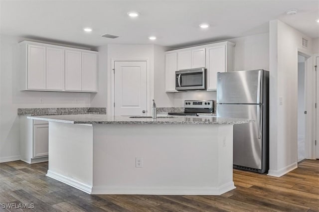 kitchen with sink, light stone counters, an island with sink, white cabinets, and appliances with stainless steel finishes