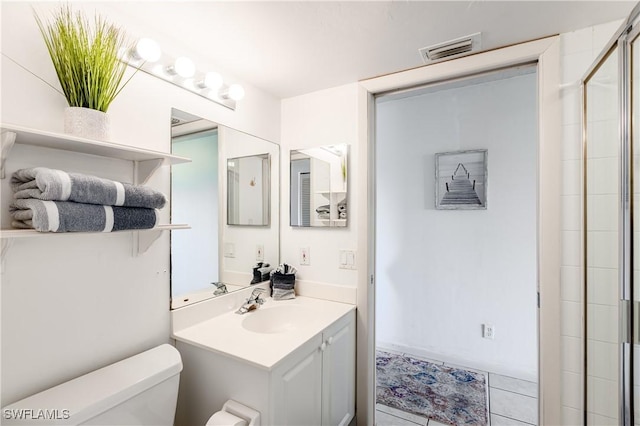 bathroom featuring tile patterned floors, walk in shower, vanity, and toilet