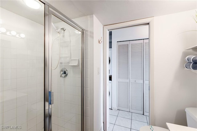 bathroom featuring tile patterned flooring, toilet, and an enclosed shower