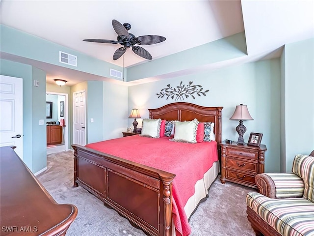 bedroom featuring ceiling fan, light carpet, connected bathroom, and a closet