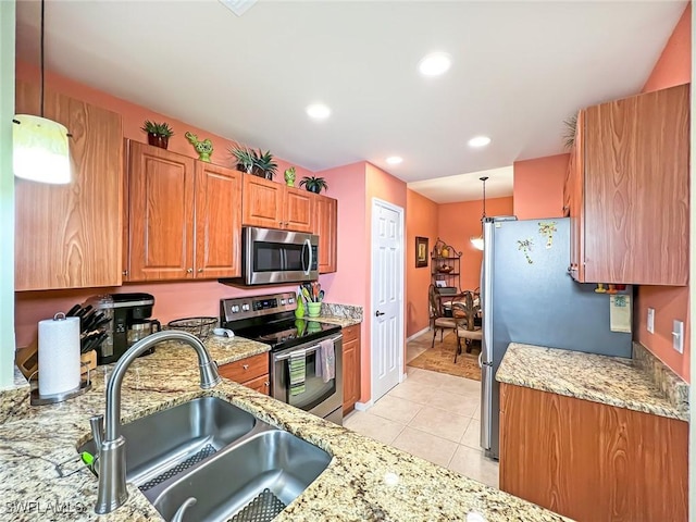 kitchen featuring light stone countertops, sink, pendant lighting, light tile patterned floors, and appliances with stainless steel finishes