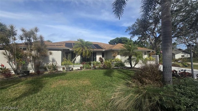 view of front of property featuring a front yard and solar panels