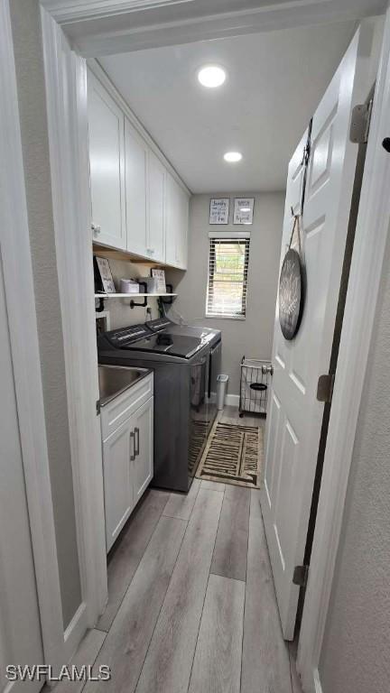 washroom with separate washer and dryer and cabinets