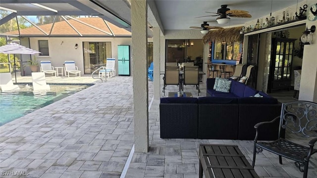 view of patio / terrace featuring outdoor lounge area, ceiling fan, and glass enclosure