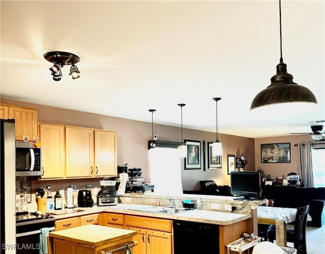 kitchen featuring black dishwasher, stainless steel microwave, a sink, gas range, and a peninsula