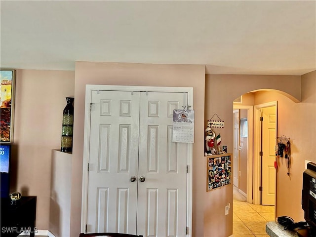 entryway with light tile patterned floors and arched walkways