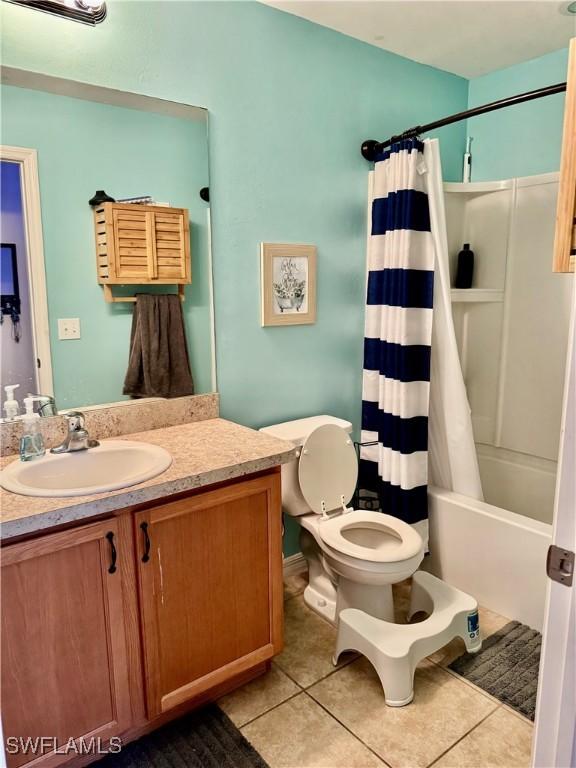 full bathroom with toilet, tile patterned flooring, shower / bath combo, and vanity