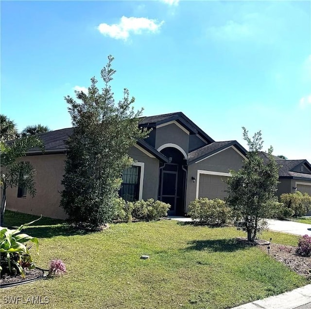 ranch-style home featuring a garage, driveway, a front yard, and stucco siding